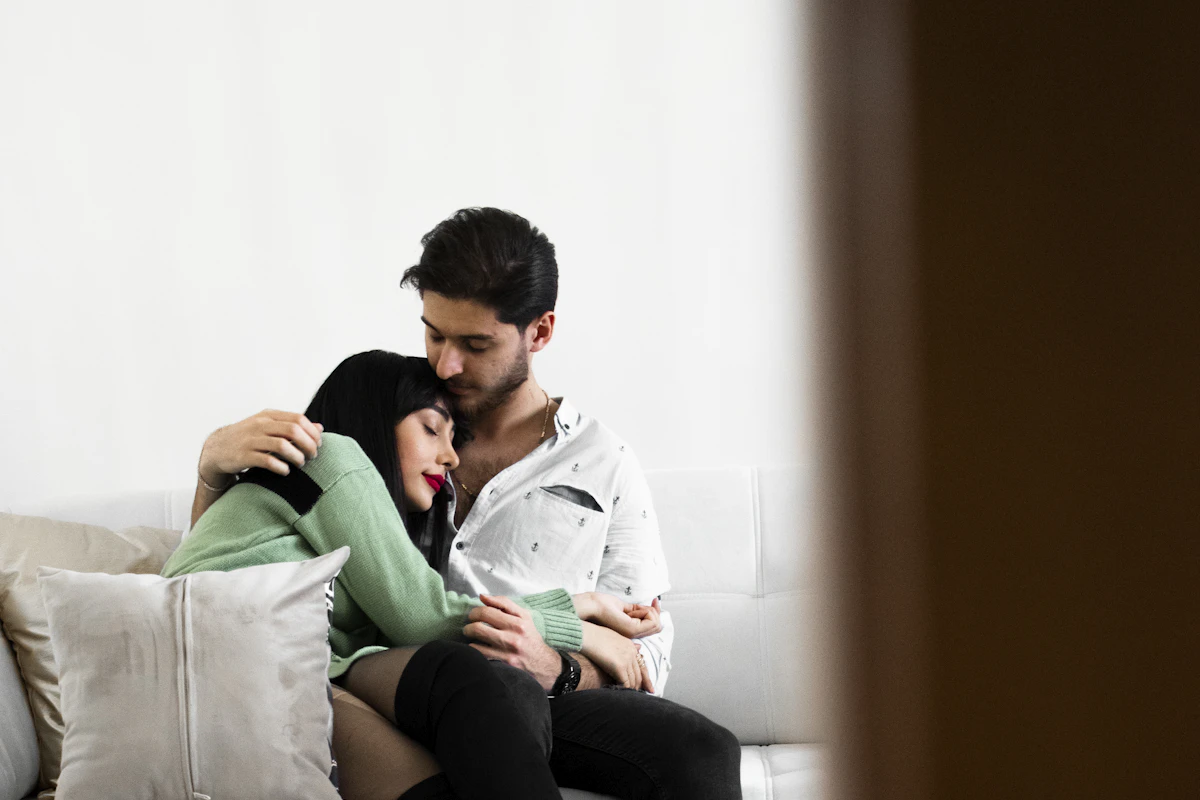 Couple tendrement enlacé sur un canapé après un moment intime