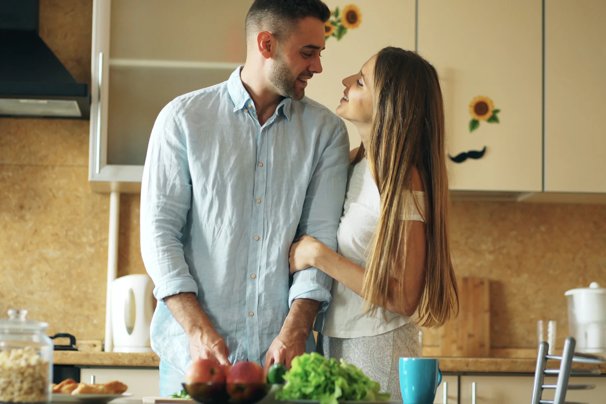 Couple complice qui cuisine ensemble dans sa cuisine