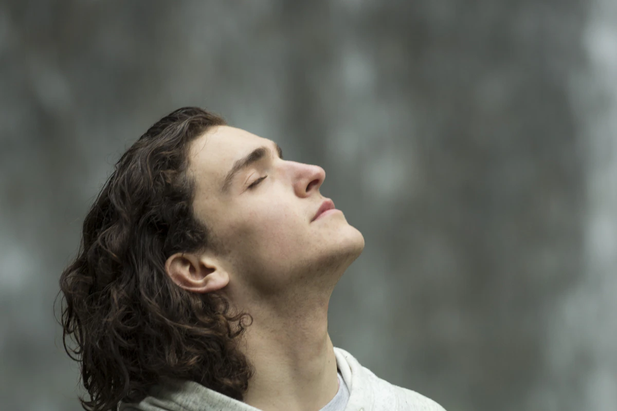 Jeune homme qui respire profondément, les yeux fermés, pour évacuer le stress