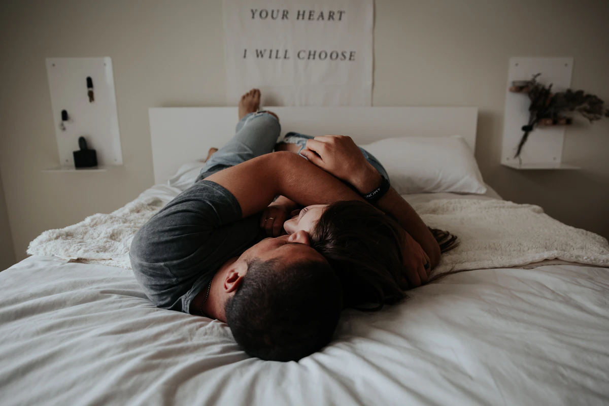Couple enlacé sur un lit, allongé l'un contre l'autre