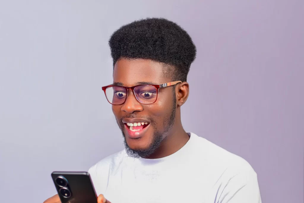 Homme enthousiaste qui répond à un message sur son smartphone